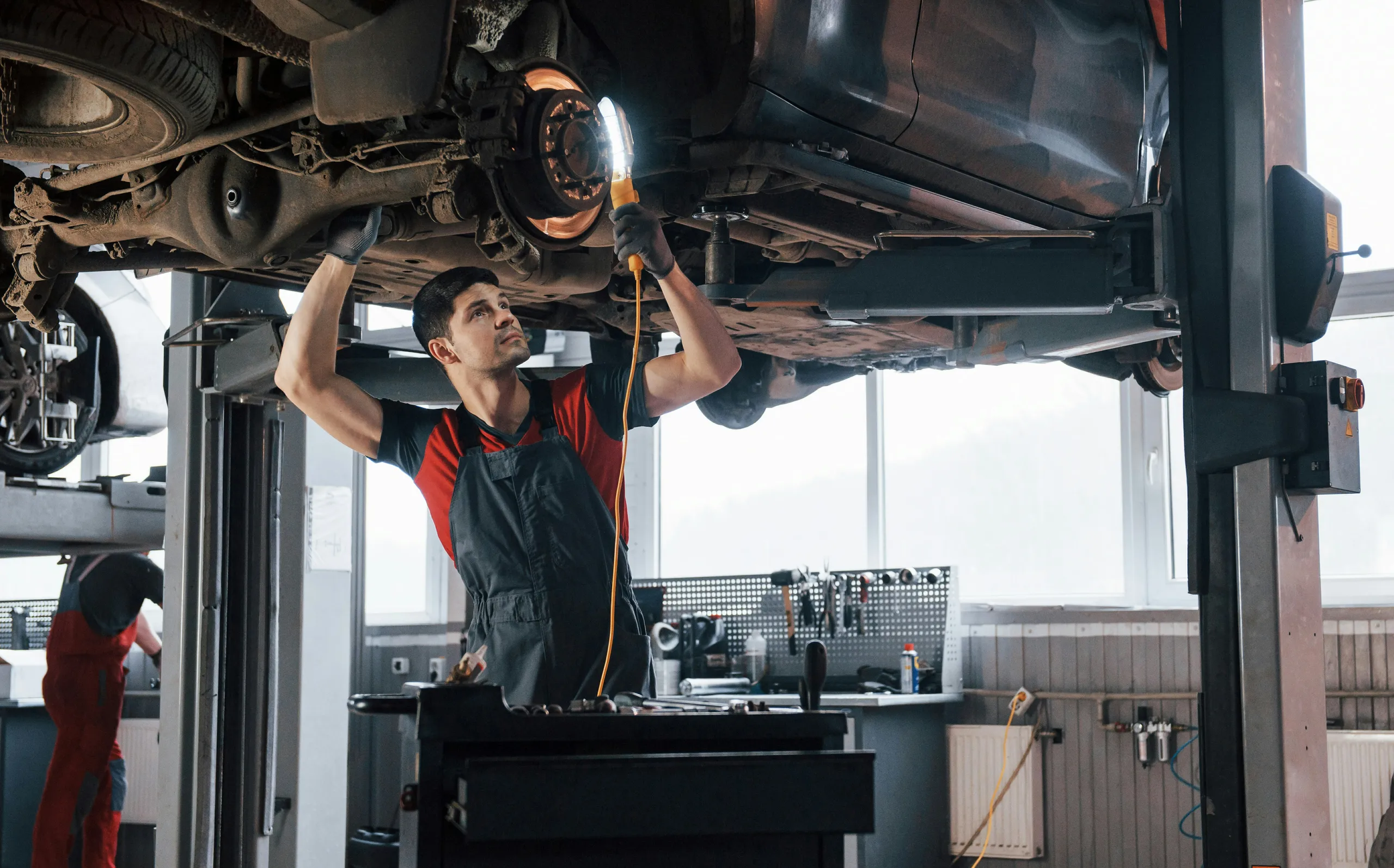 Mechanik diagnozuje usterkę auta uniesionego na podnośniku
